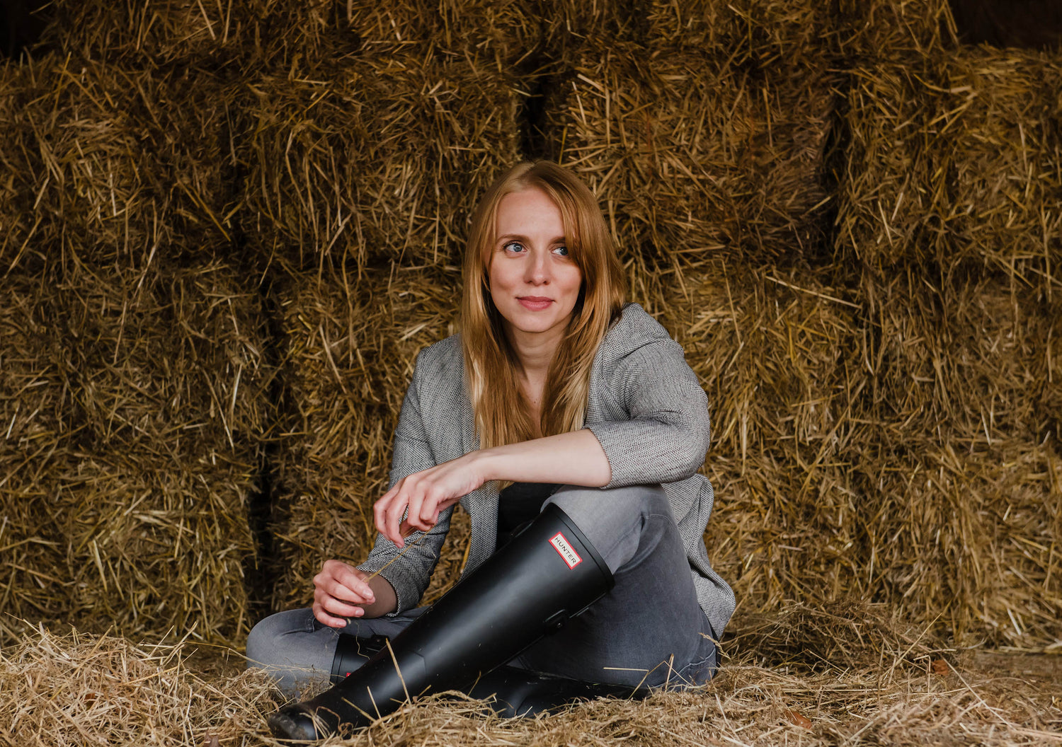 Company founder woman sitting on hay 