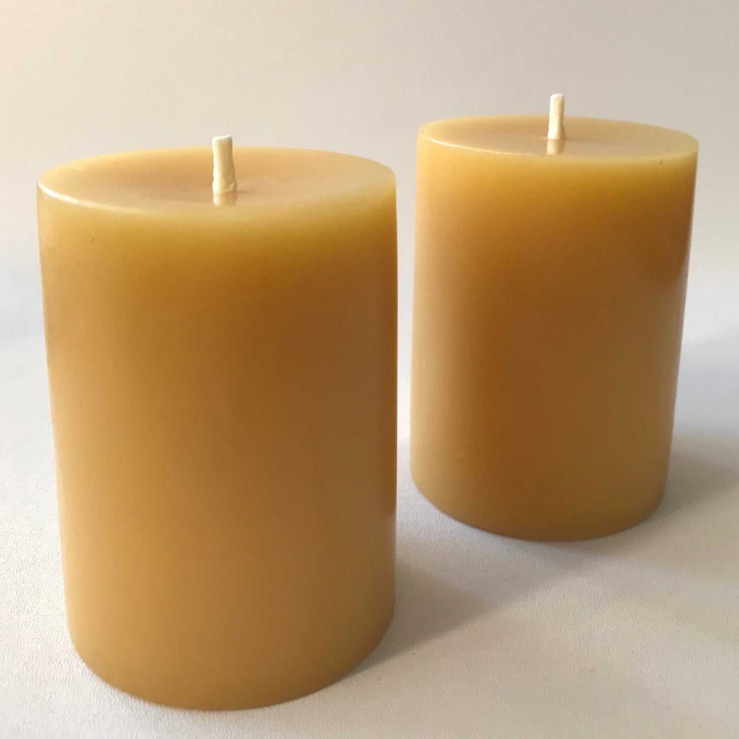 Two beeswax candles on a light background