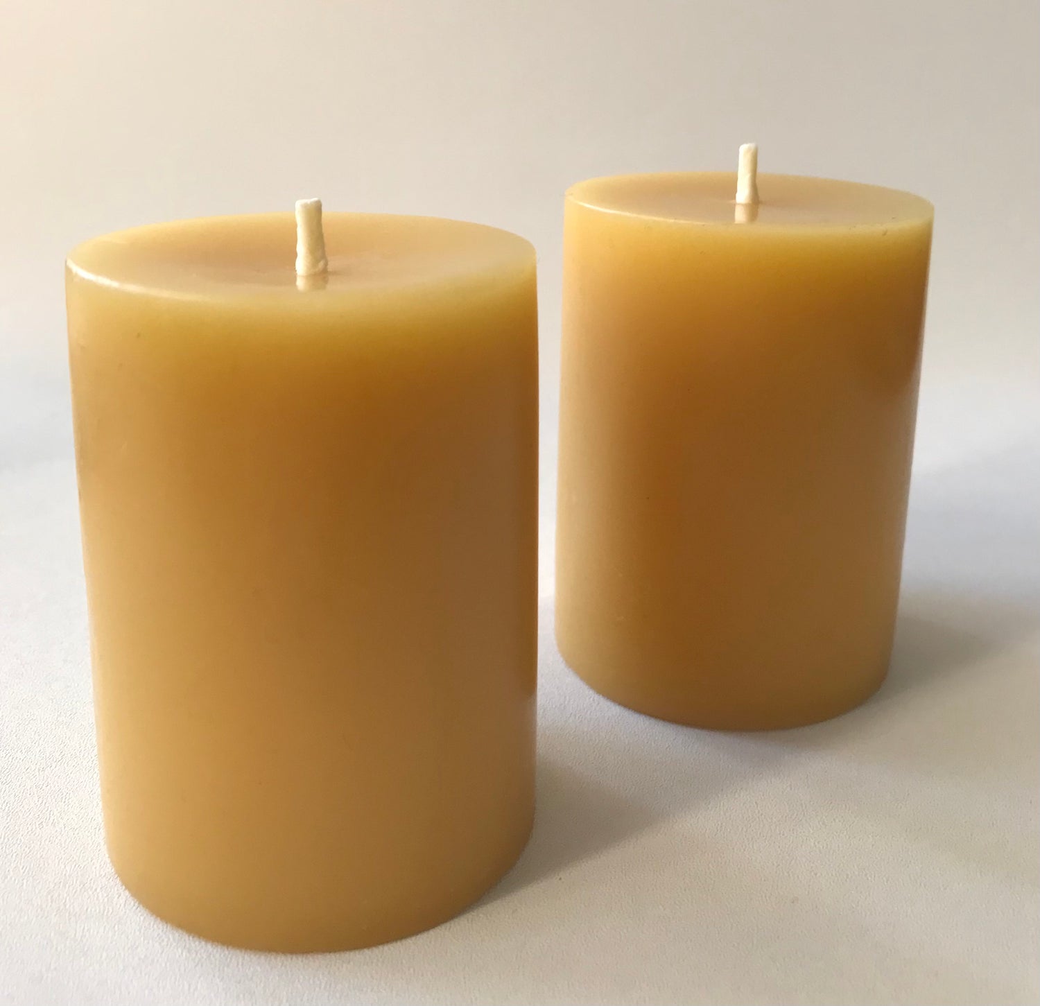 Two beeswax candles on a light background